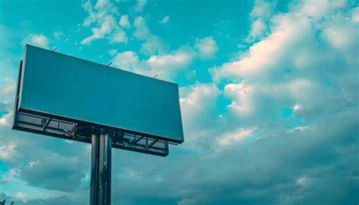 A billboard with a blue sky behind it.