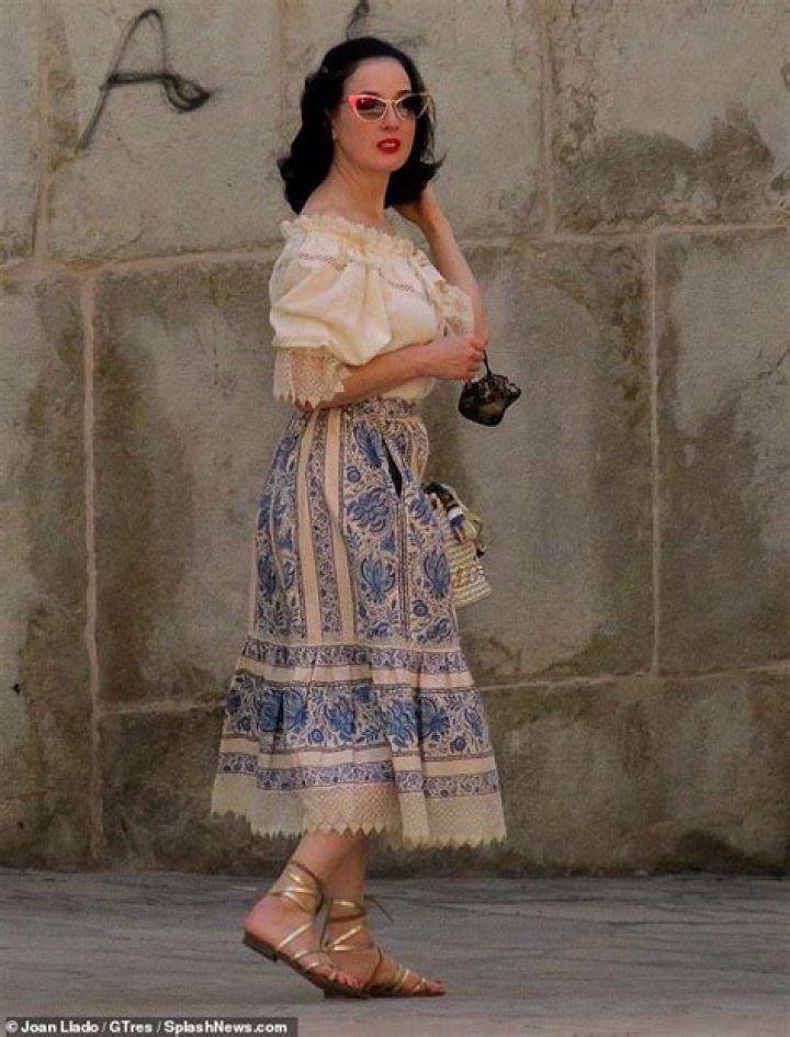 Dita Von Teese looks typically chic in patterned blue midi skirt